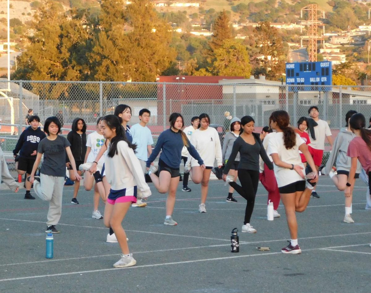 FLAMINGO! Aspiring badminton players stretch after a long day of conditioning.