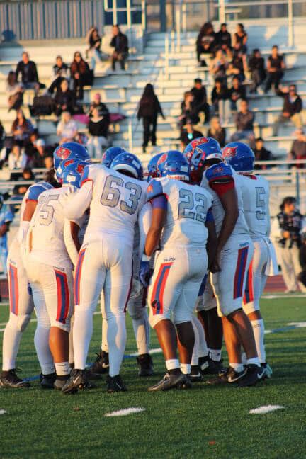Jayvion Ribas (#75), Charles Ekpenyong (#63), Lawrence Patterson (#22), Jaymieon Bradley (#5) and the rest of the pirate's offense huddling up.